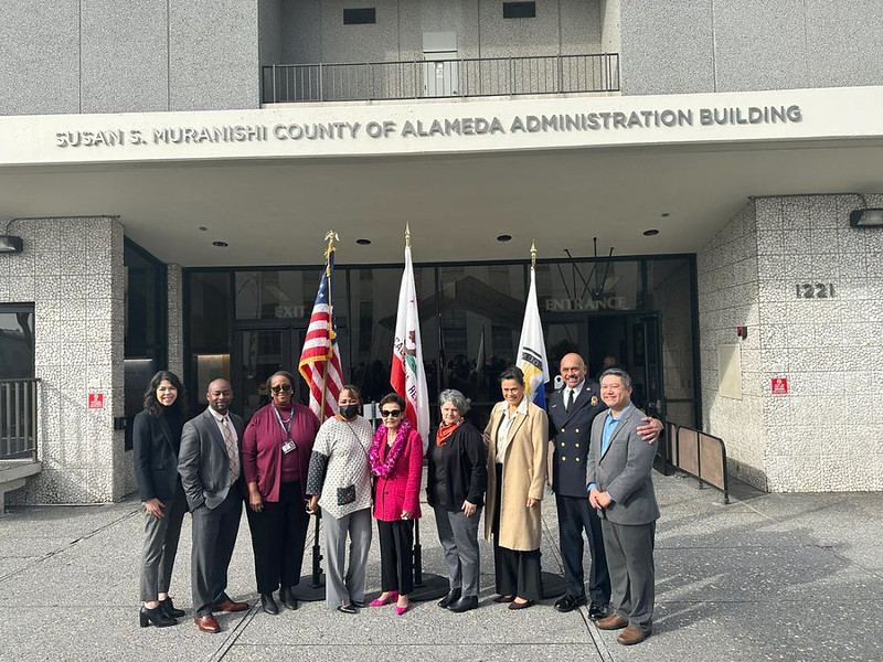 Susan S. Muranishi and department heads stand in front of the newly renamed Susan S. Muranishi County of Alameda Administration Building.